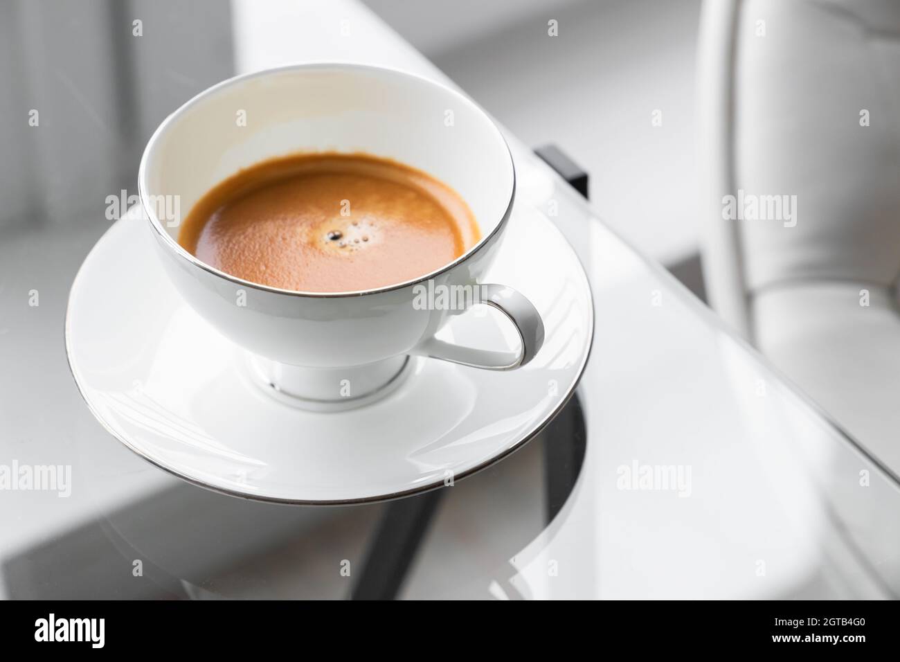 https://c8.alamy.com/comp/2GTB4G0/espresso-coffee-in-a-white-cup-stands-on-a-glass-table-closeup-photo-with-selective-focus-2GTB4G0.jpg