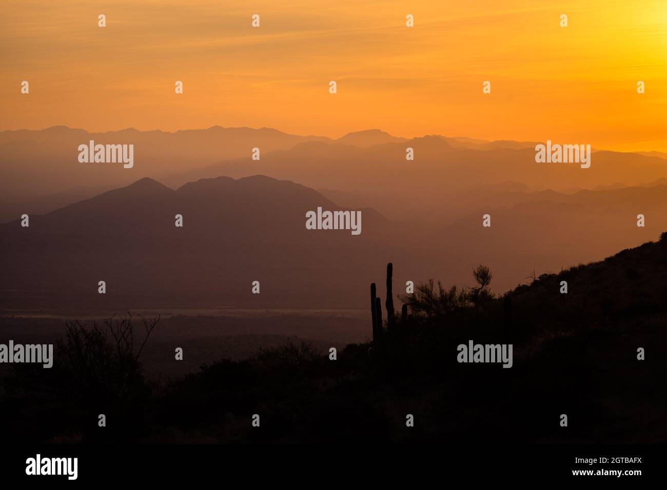 Scenic View Of Silhouette Mountains Against Orange Sky During Sunrise Stock Photo