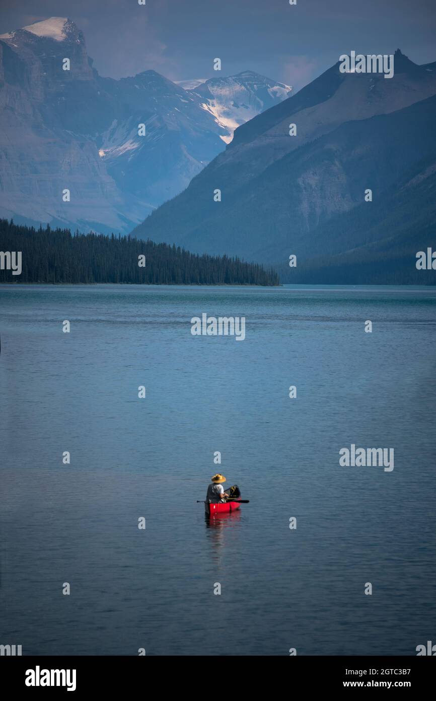 Single person in red canoe on mountain lake Stock Photo