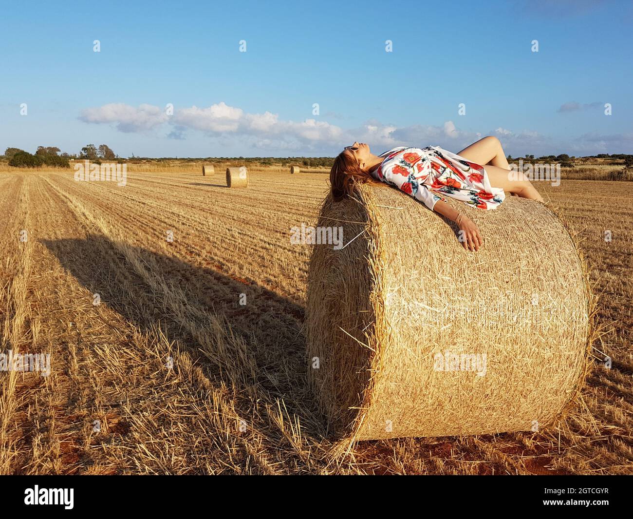 Woman With Hay Bales On Field Against Sky Woman Lying In Hay Bales Stock Photo Alamy