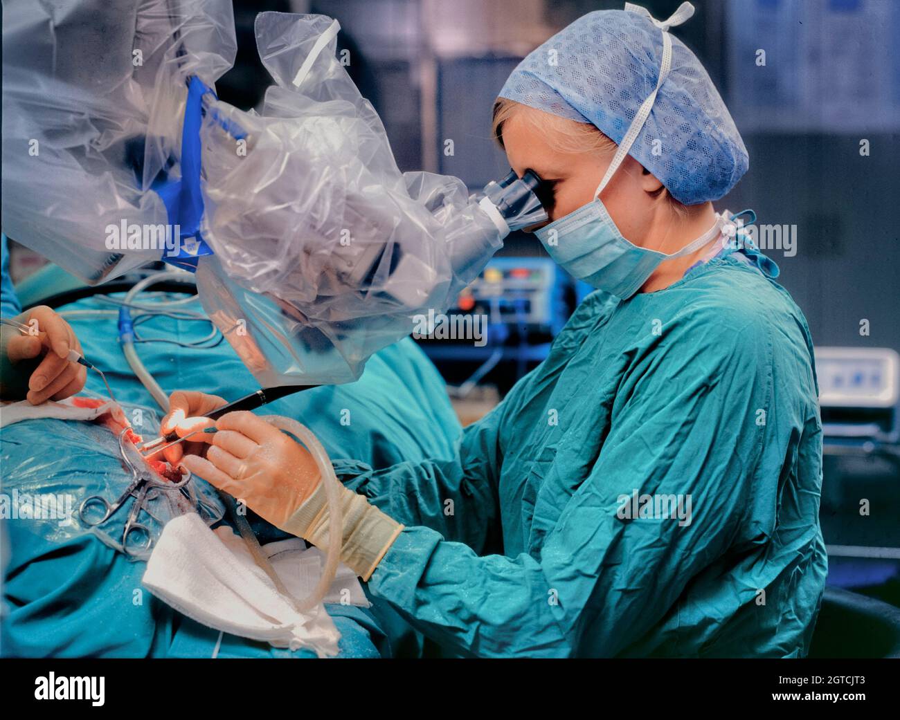 A woman surgeon implanting a cochlear receiver into a patient. Stock Photo