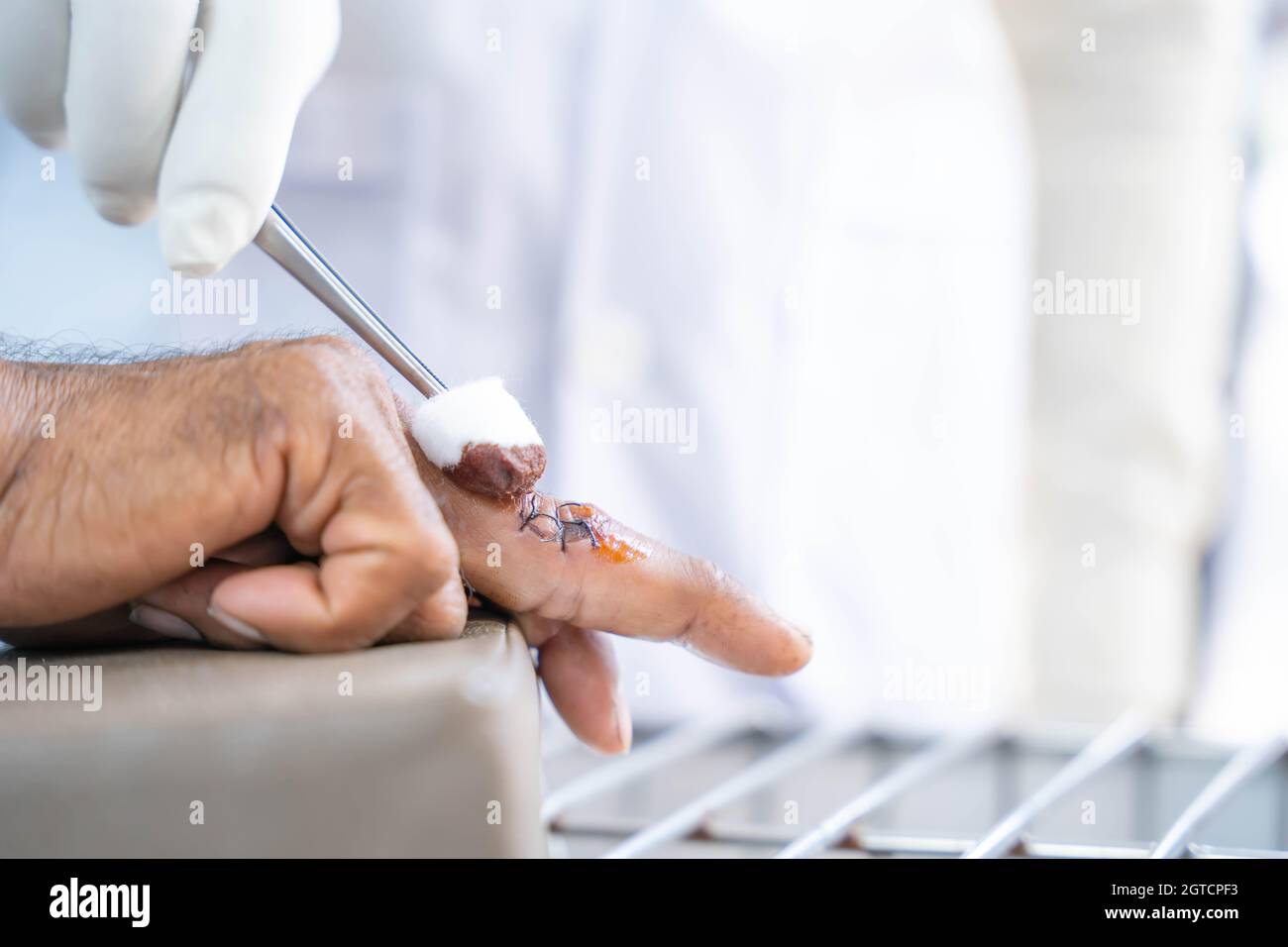 A doctor in white clothes, wearing white antigerm gloves, is cleaning
