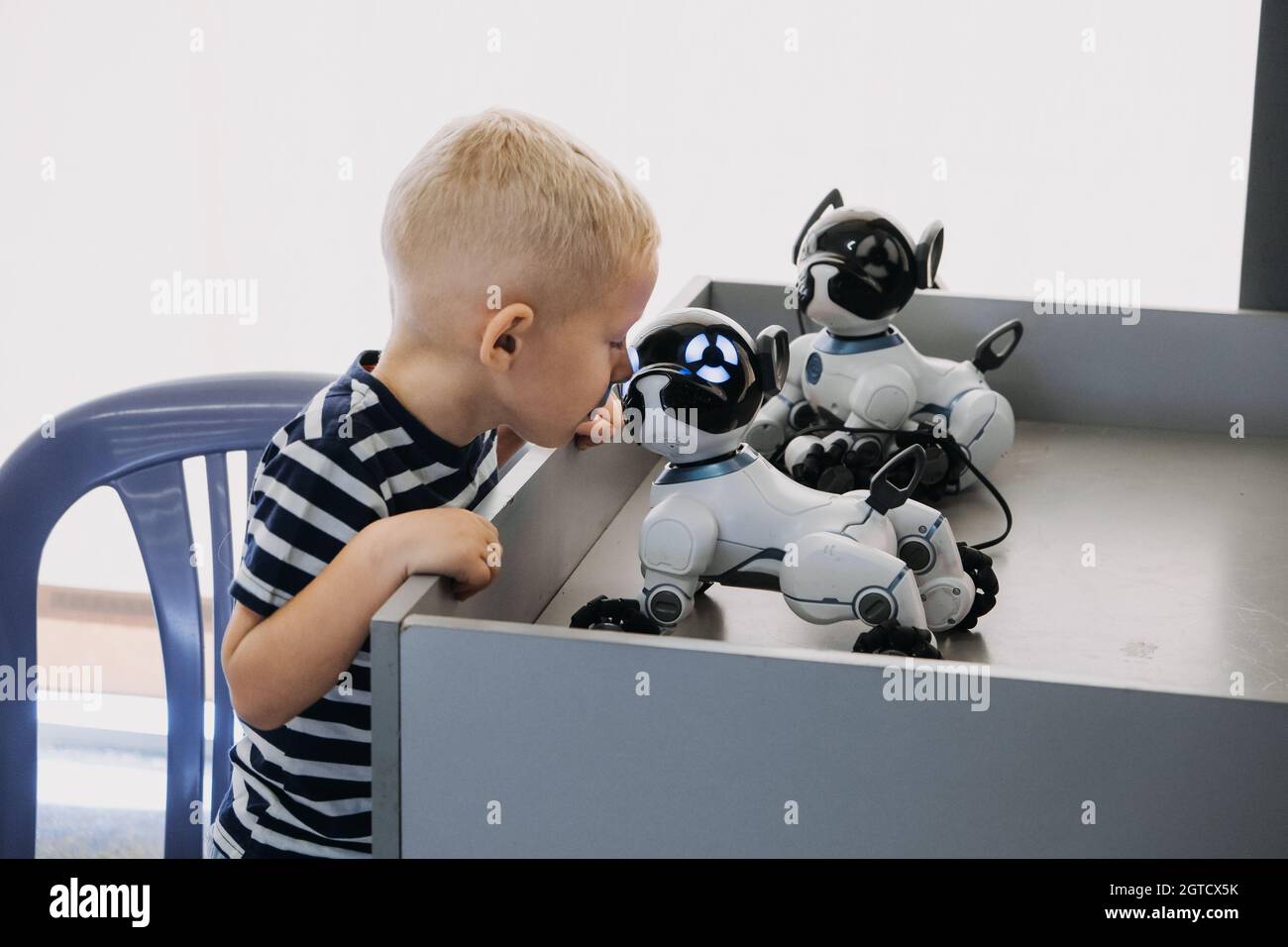 Little Boy Playing With Interactive Remote Control Robot Dog Toy. Kid And  Smart Dancing Robot Stock Photo - Alamy