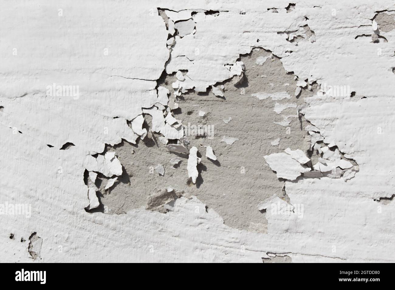 Gray wall with peeling gray paint. Old shabby gray concrete wall with