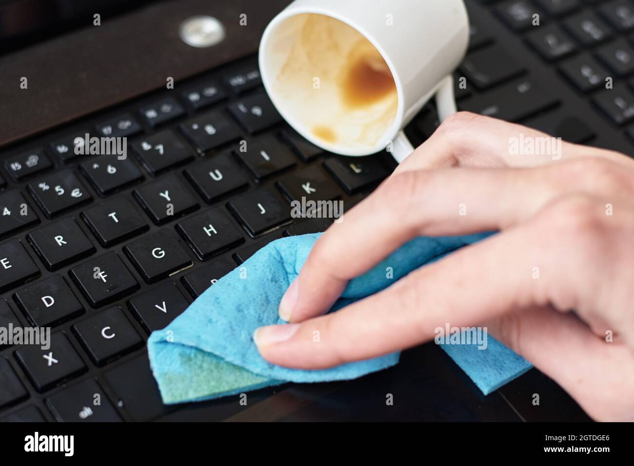 Hand Cleans Spilled Coffee On Laptop Keyboard With Rag Stock Photo Alamy
