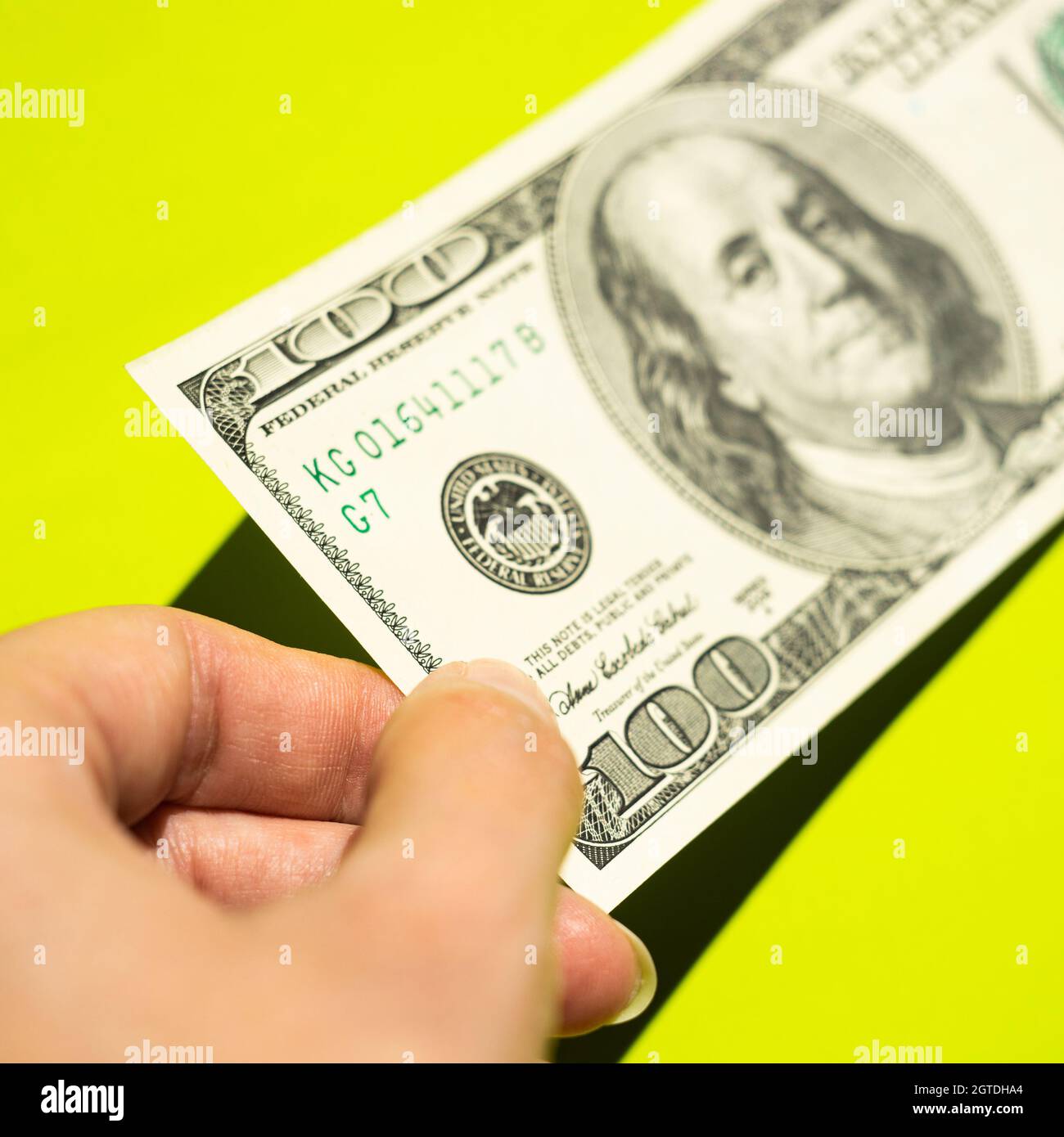 Hand With 100 Dollar Bill On A Vivid Green Table With Shadows From The Bright Sun Stock Photo Alamy Hand With 100 Dollar Bill On A Vivid Green Table With Shadows From The Bright Sun Stock Photo Alamy