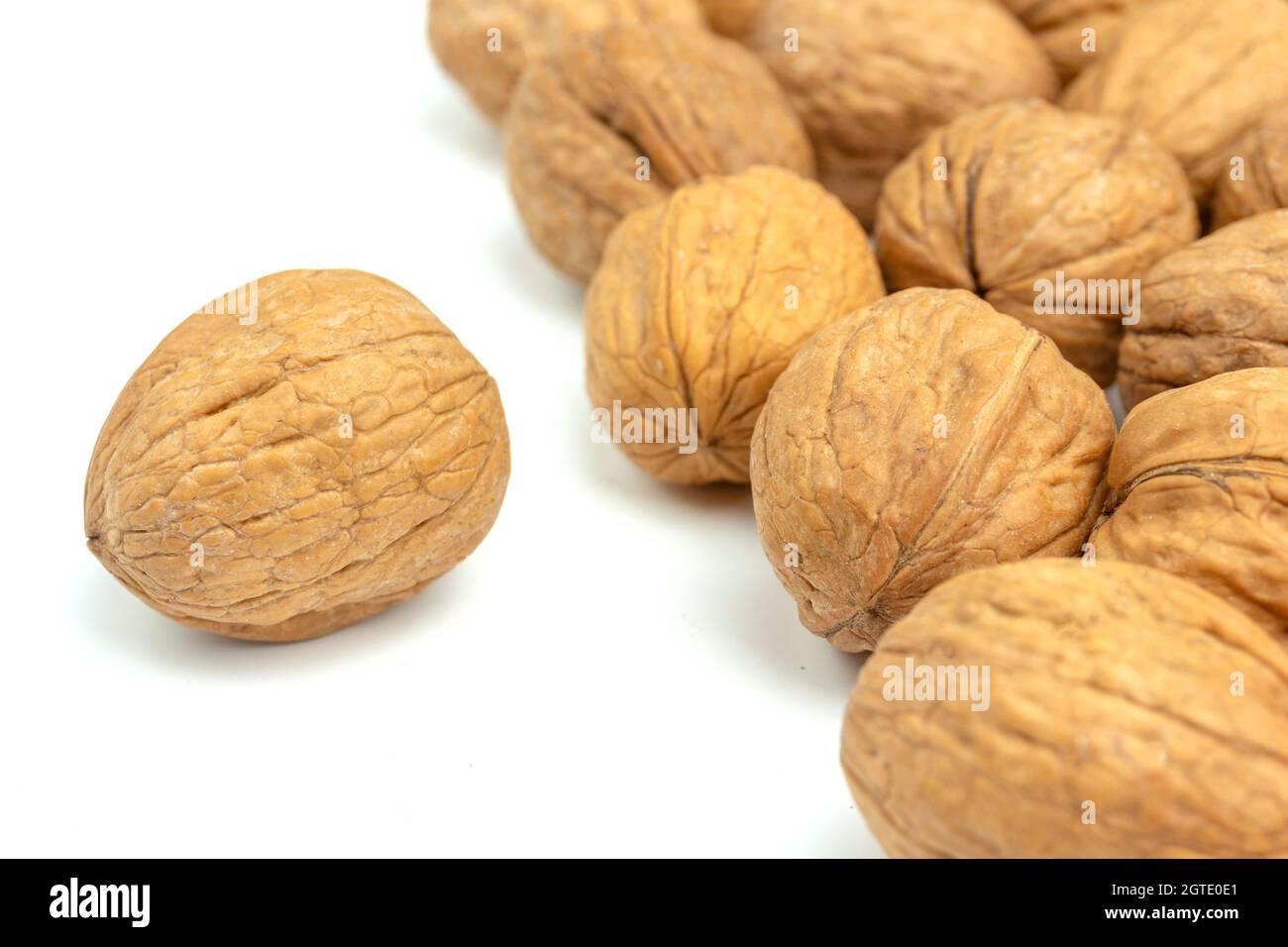 Close-up Of Walnuts Isolated On White Background. Raw Fruits On Table Against White Background. Stock Photo