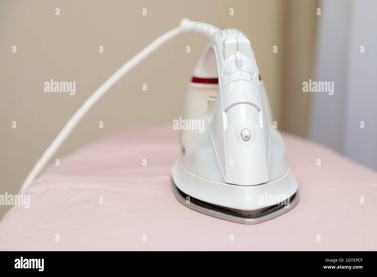 Iron On Ironing Board With Pink Linens. Closeup Stock Photo Alamy