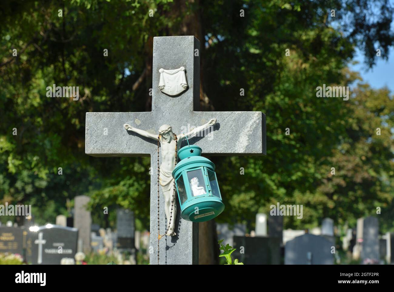 Vienna, Austria. The Vienna Central Cemetery. Stone cross with Jesus figure and grave lantern Stock Photo