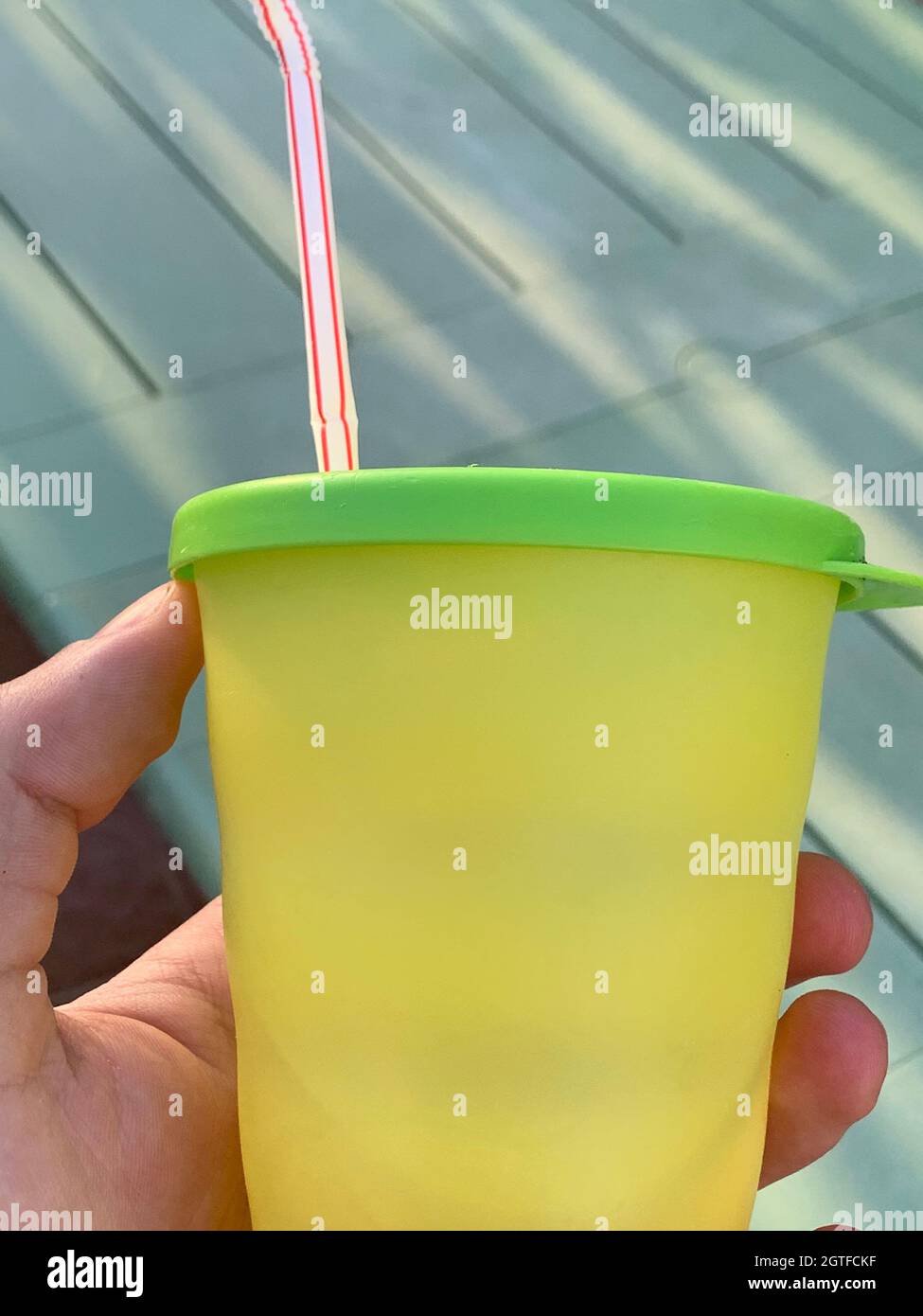 Close-up Of Hand Holding Plastic Cup With Drinking Straw Stock Photo