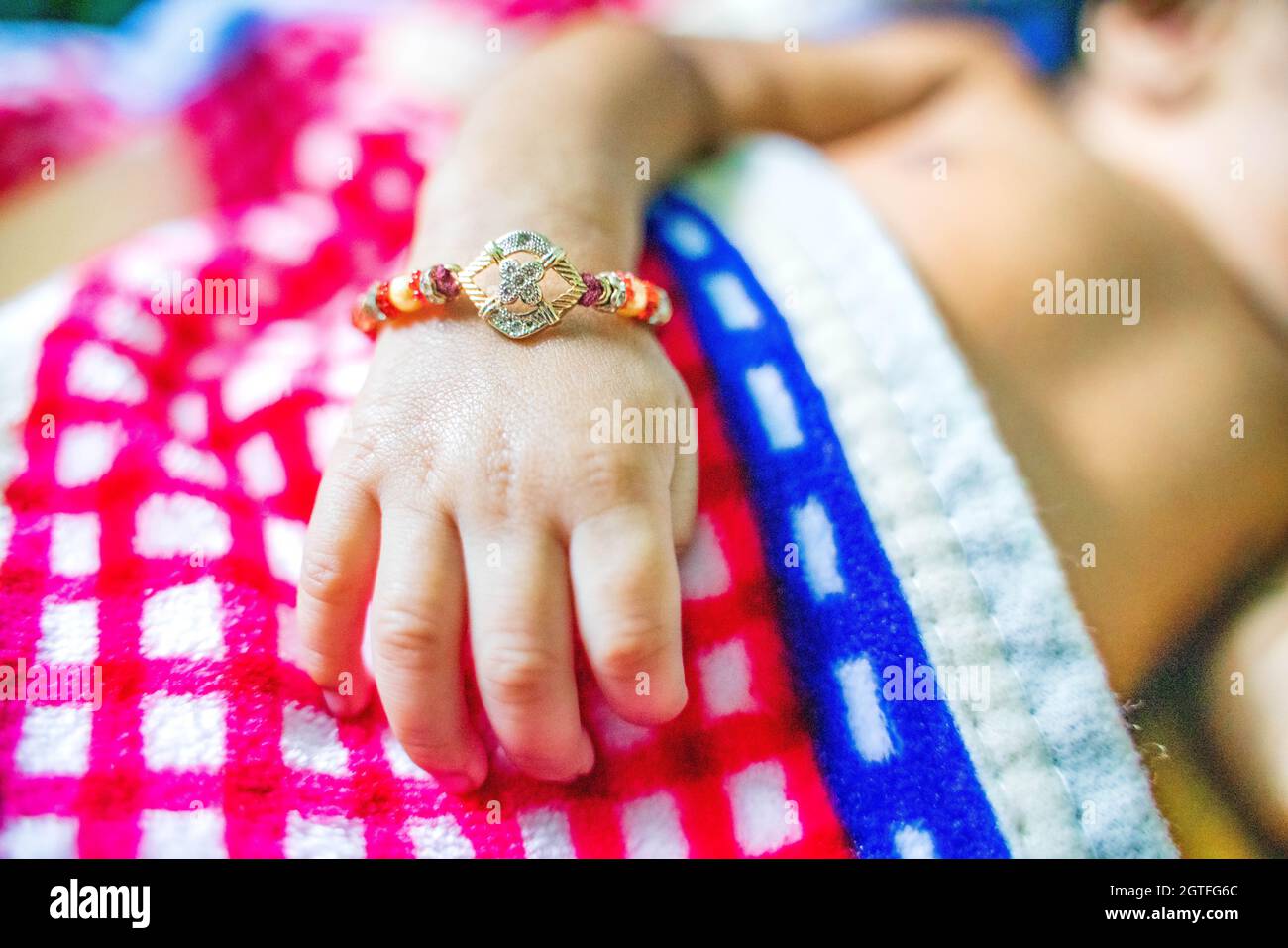 Midsection Of Baby Wearing Rakhi Stock Photo