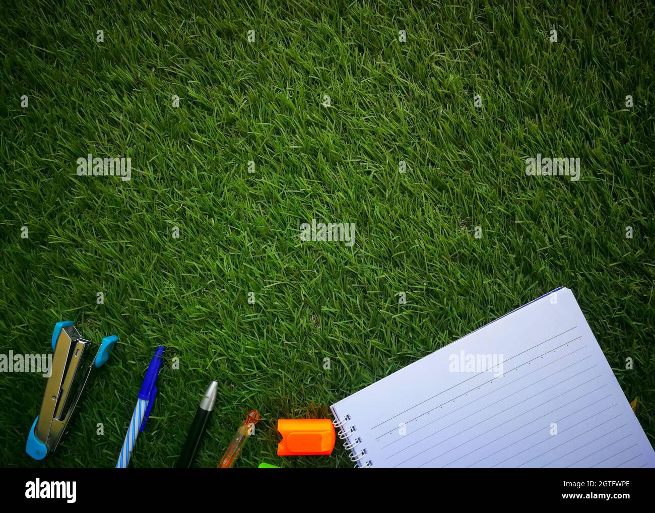 Directly Above Shot Of Office Supplies On Grassy Field Stock Photo