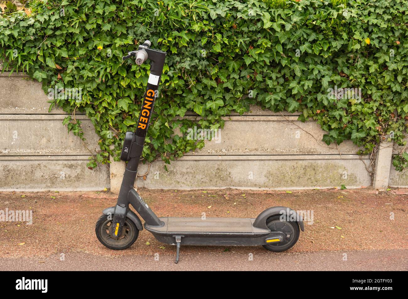 Unattended Ginger brand electric scooter stood up on its stand on the pavement in Great Yarmouth