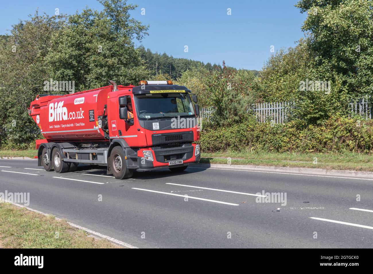 Biffa Volvo FE tanker truck travelling uphill on country road. For UK driver shortage, waste management during Covid, UK transport. Copy space. Stock Photo