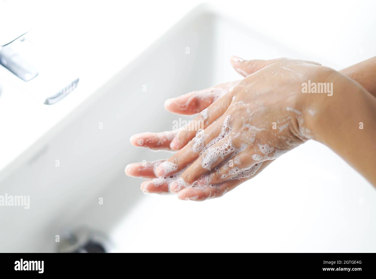 Cropped Image Of Woman Washing Hands In Sink At Bathroom Stock Photo