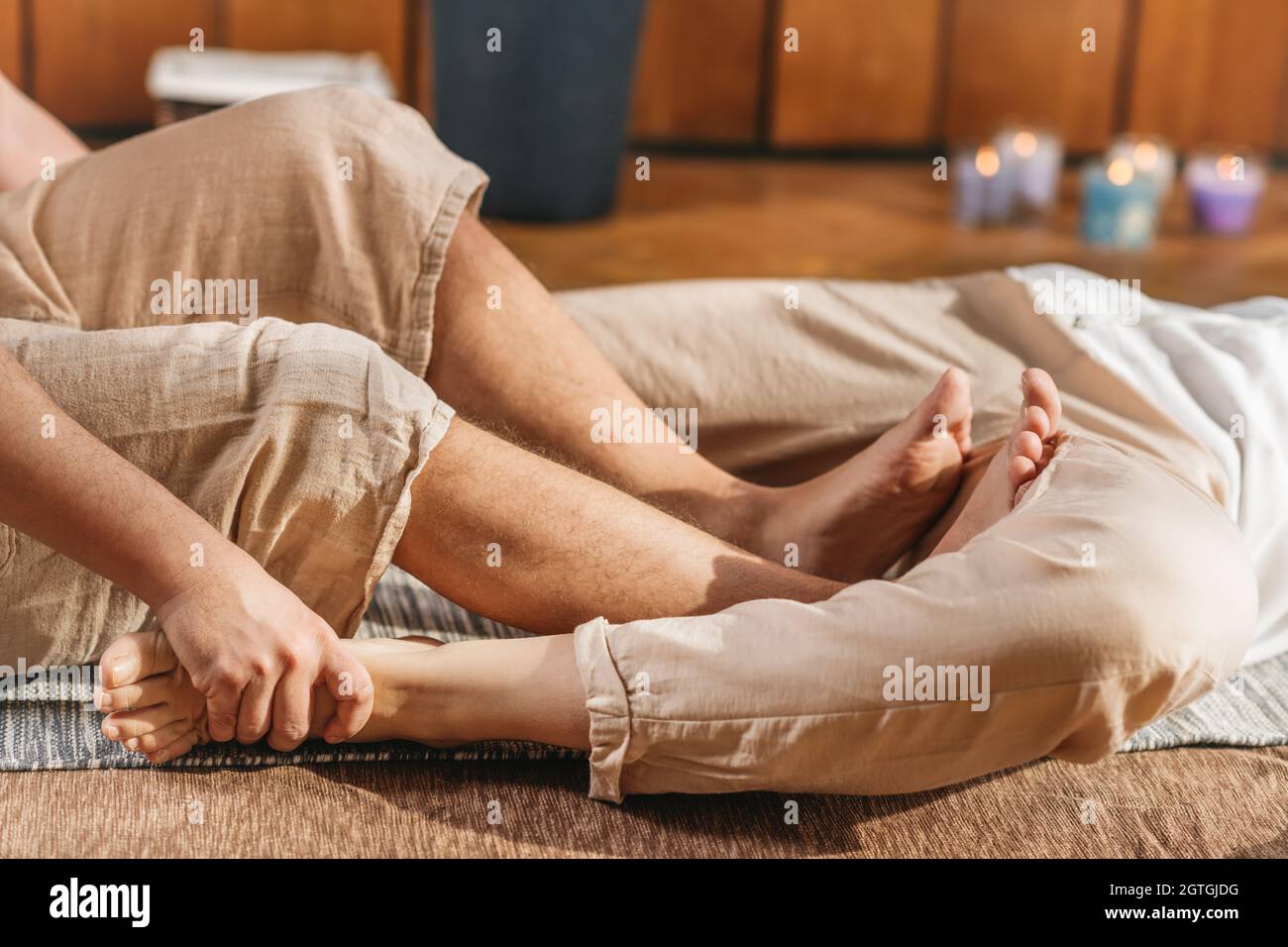Thai Full Body Massage - Hip Stretching. Thai Massage Male Practitioner  Pressing The Female Client Stock Photo - Alamy