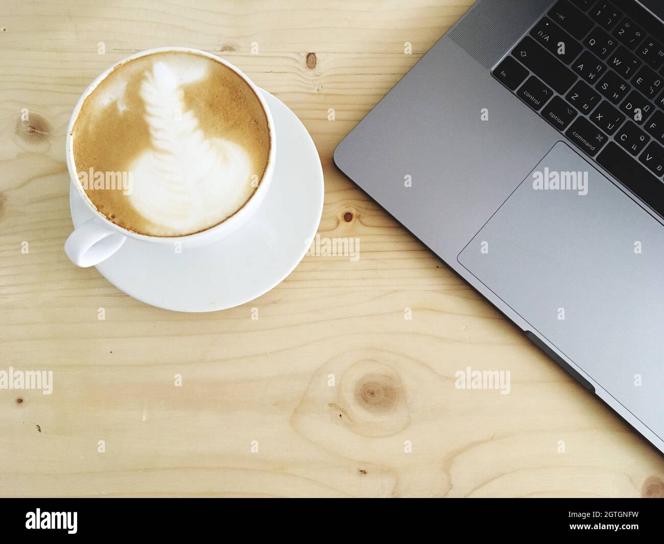 High Angle View Of Coffee And Laptop On Table Stock Photo