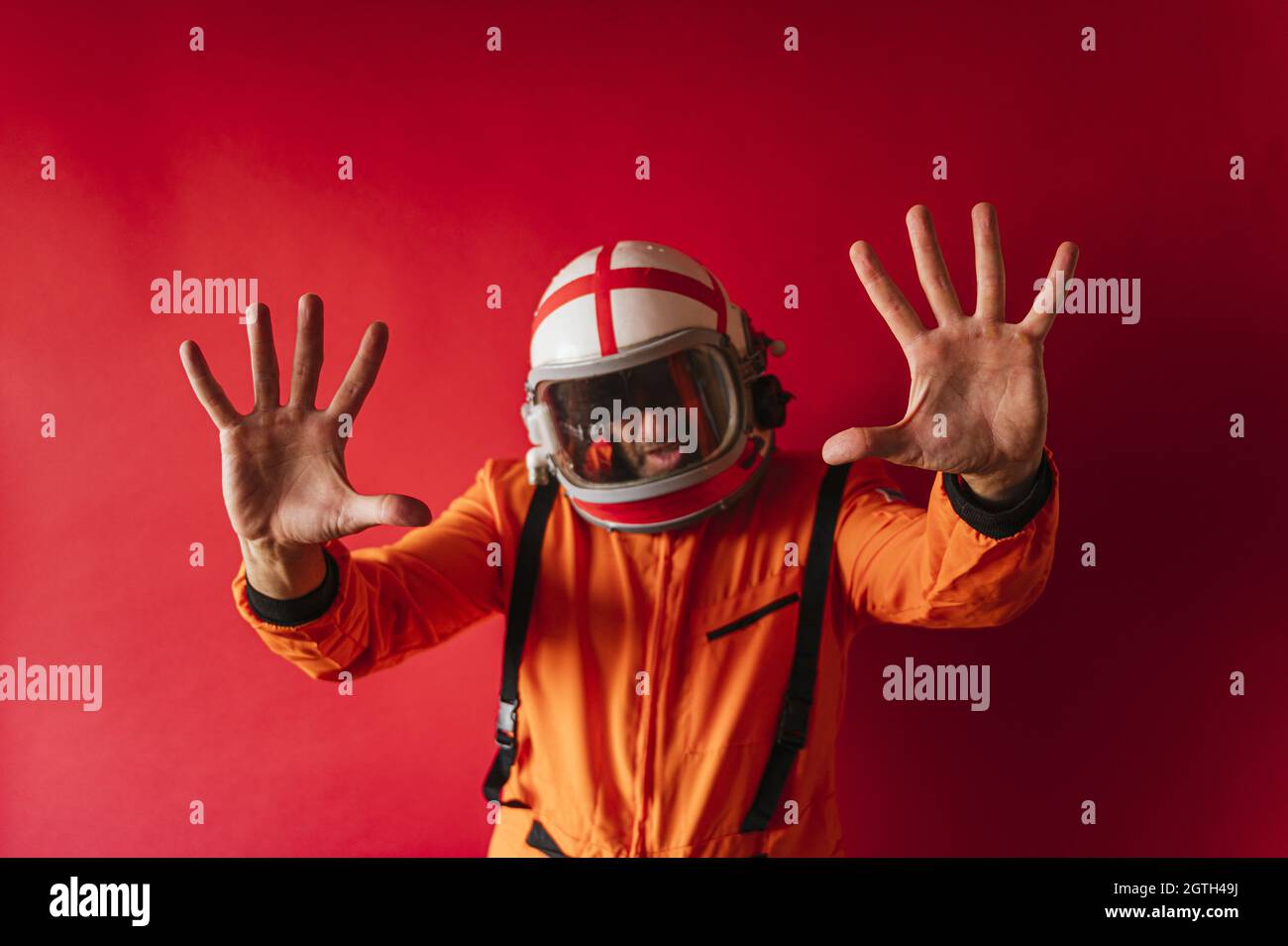 Astronaut with an orange space suit moving on a red background Stock Photo - Alamy Astronaut with an orange space suit moving on a red background Stock Photo - Alamy