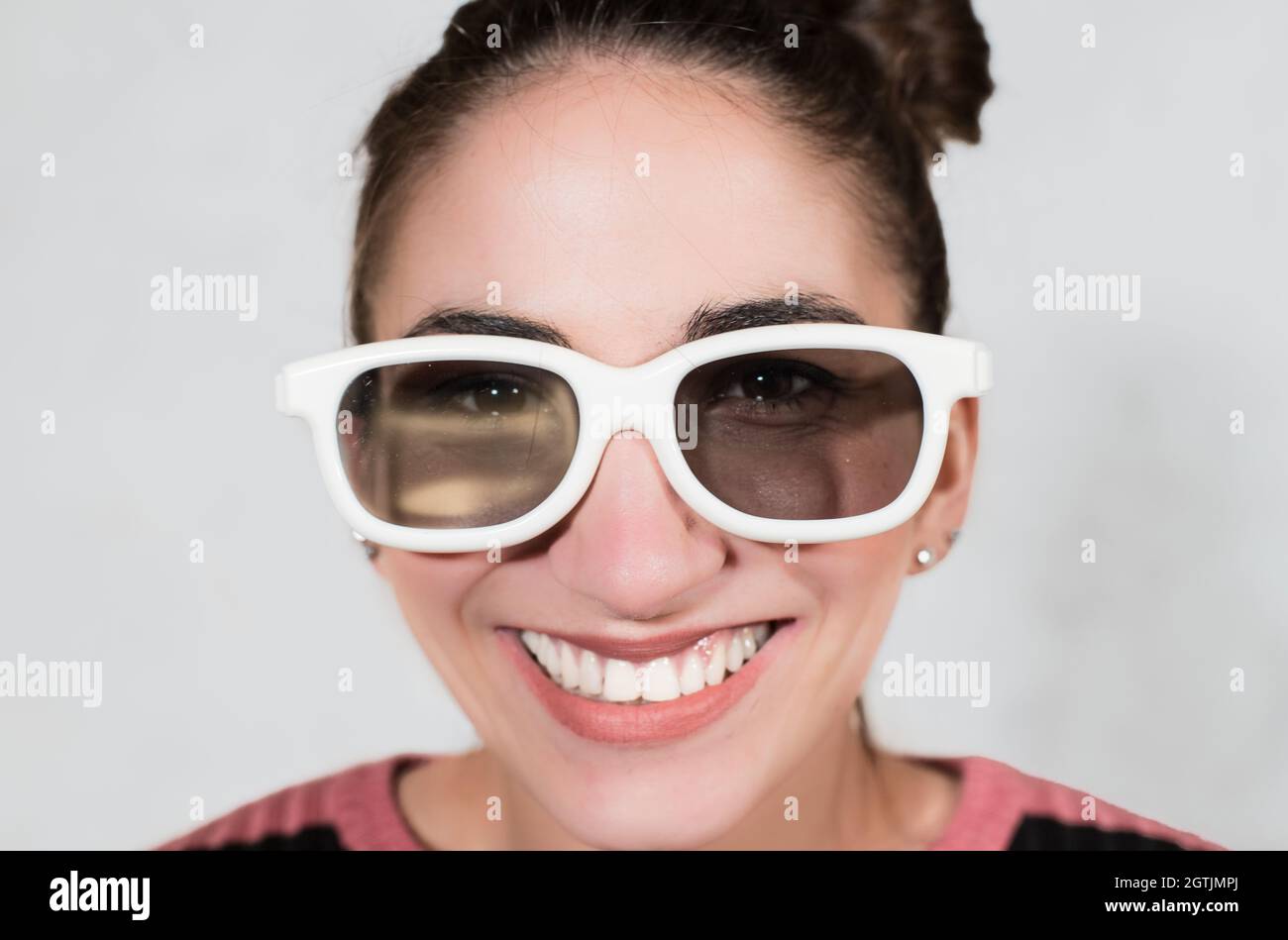 Portrait Of Smiling Young Woman Wearing Sunglasses Against White Background Stock Photo