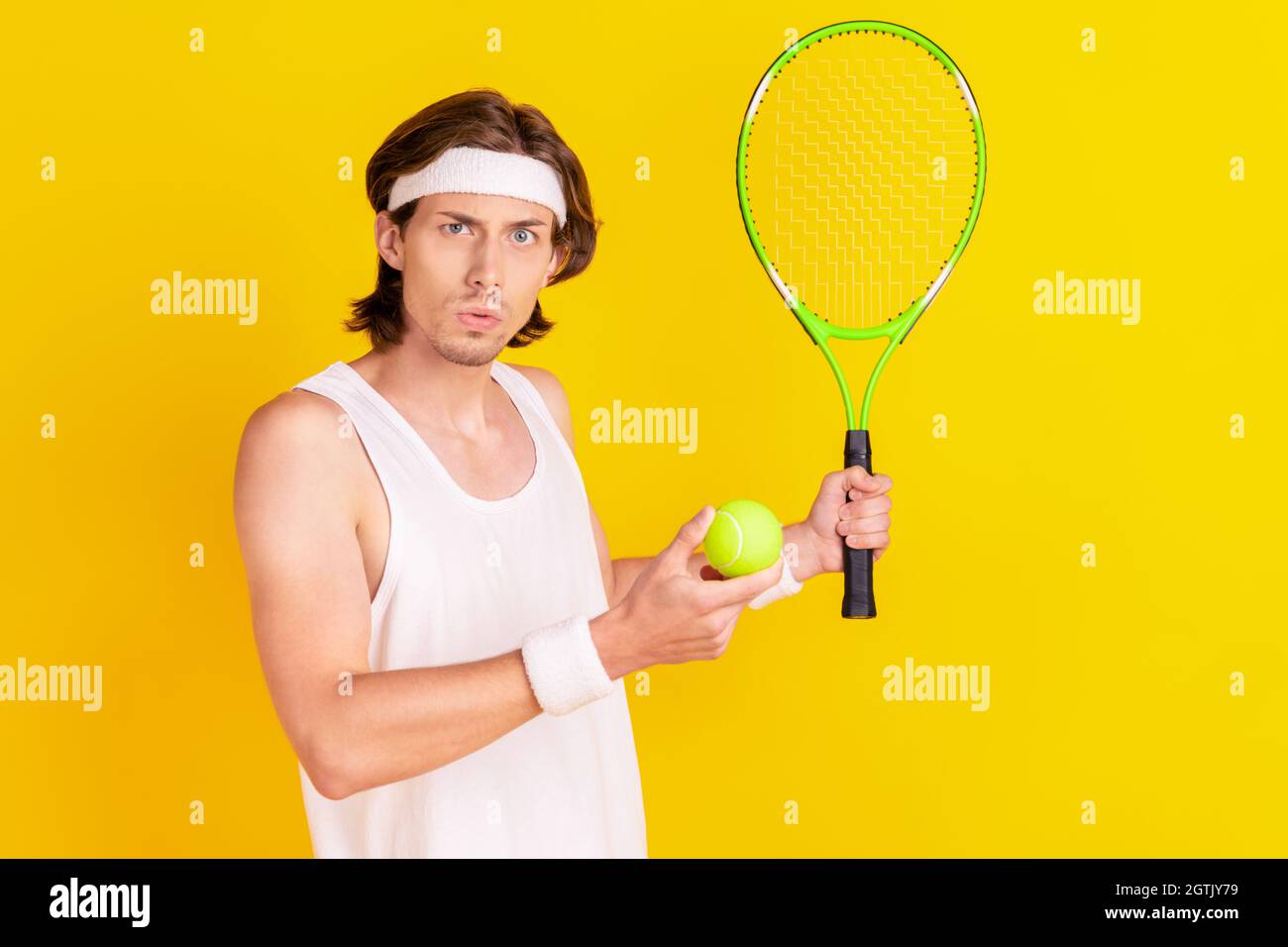 Portrait of attractive focused guy playing tennis throwing ball pass