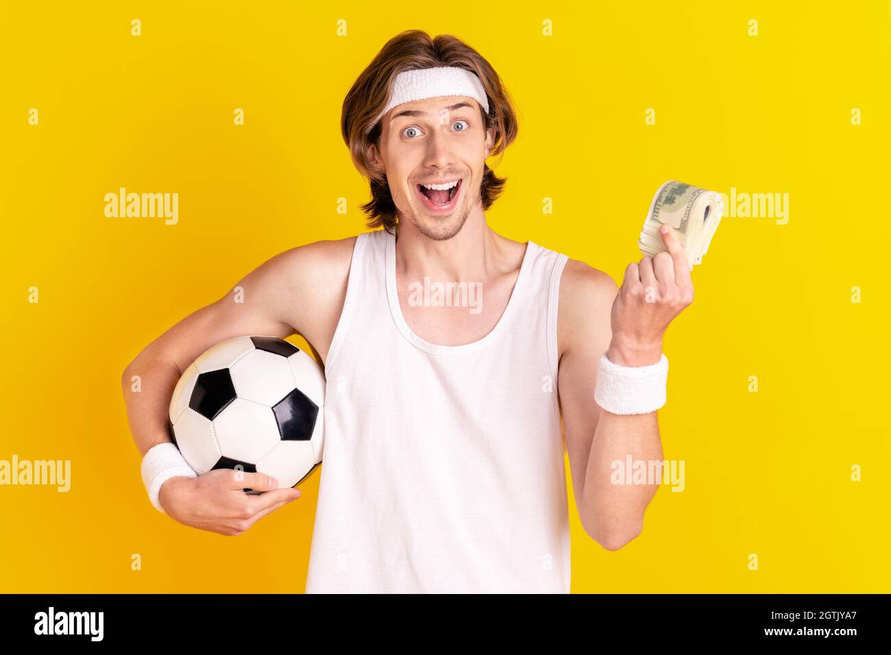 Portrait of handsome cheerful guy holding bunch usd soccer ball salary
