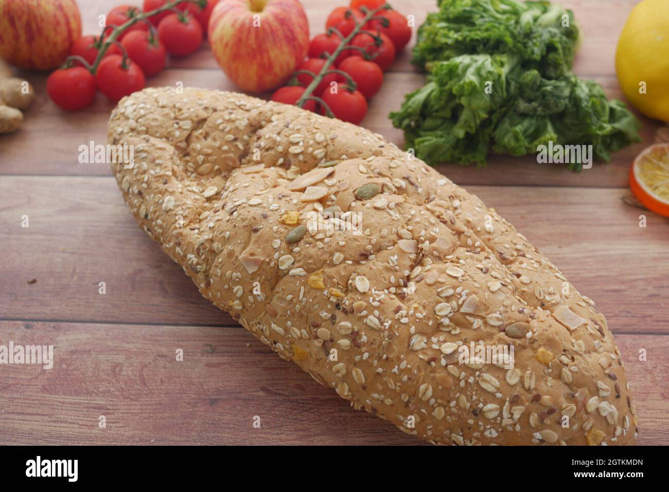 whole meal bread, apple and cherry tomato on table Stock Photo