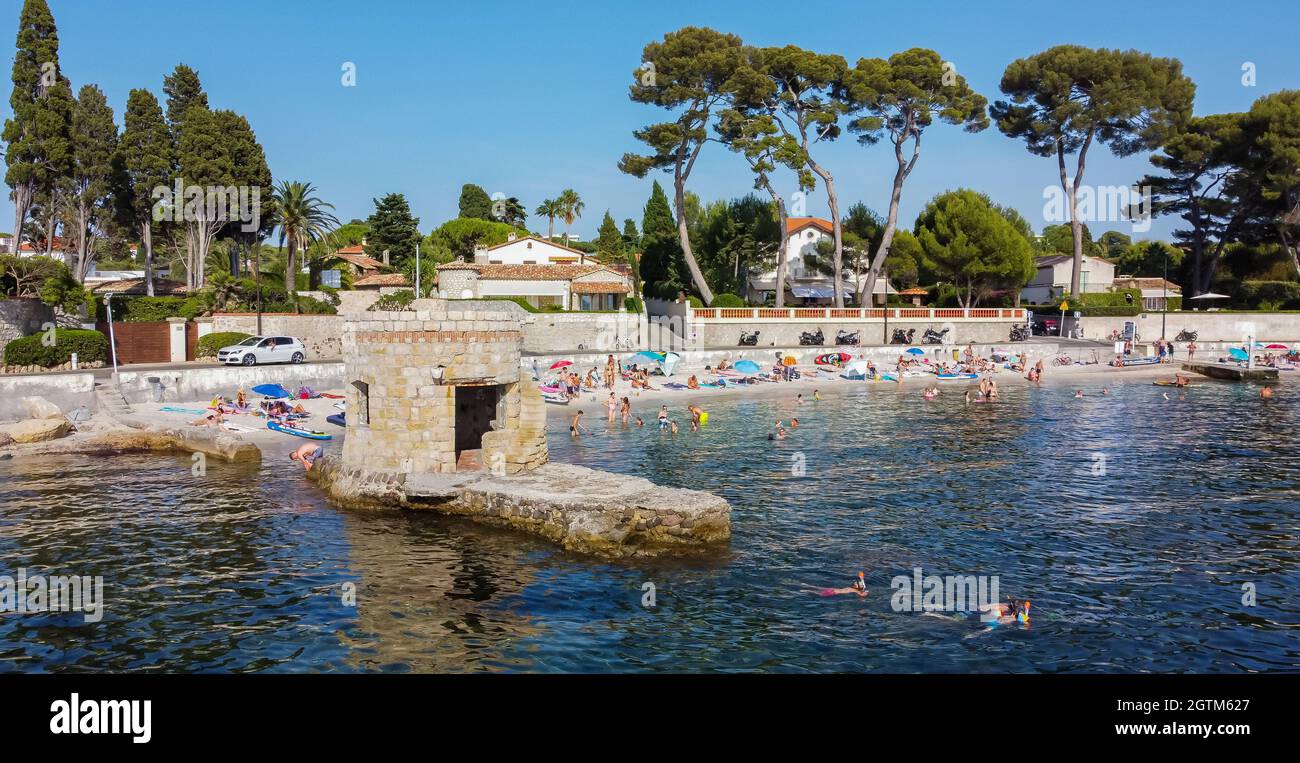 Aerial view of Ondes Beach on the Cap d'Antibes in the French Riviera - Ruins of a flooded round watch tower in the Mediterranean Sea Stock Photo