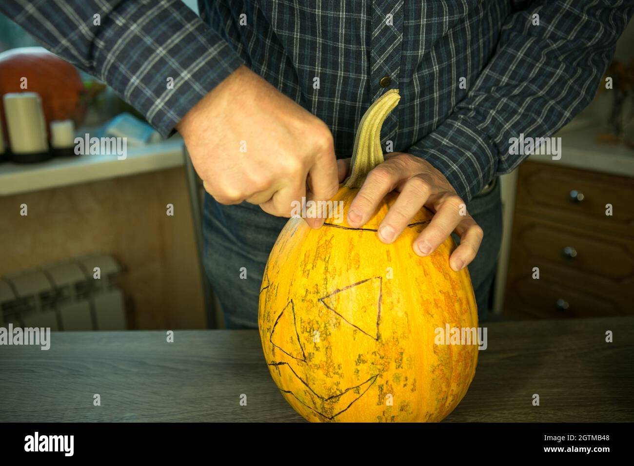 Halloween. How to make Jack O'Lantern at home? Male hands with knife ...
