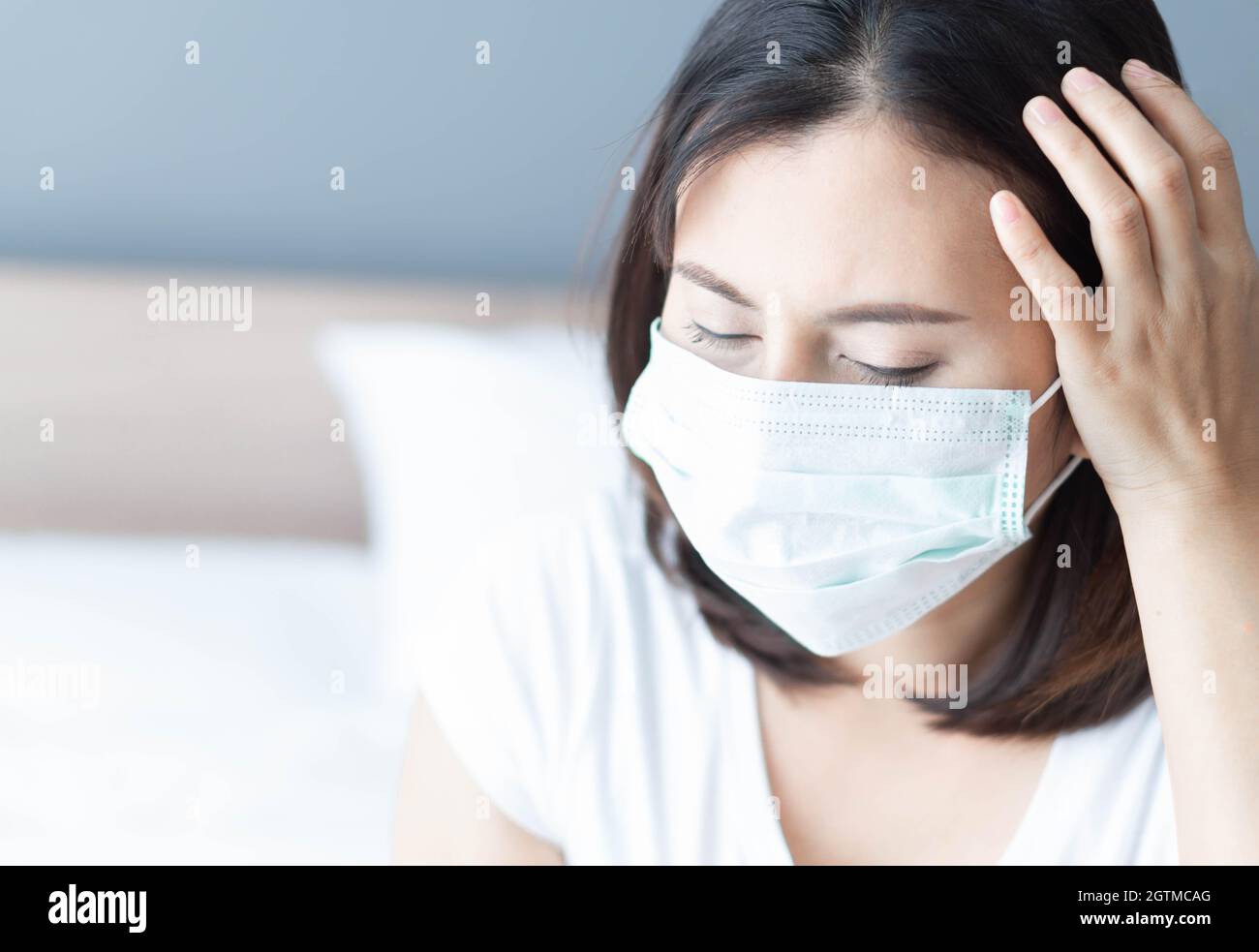 Mid Adult Woman Wearing Flu Mask At Home Stock Photo
