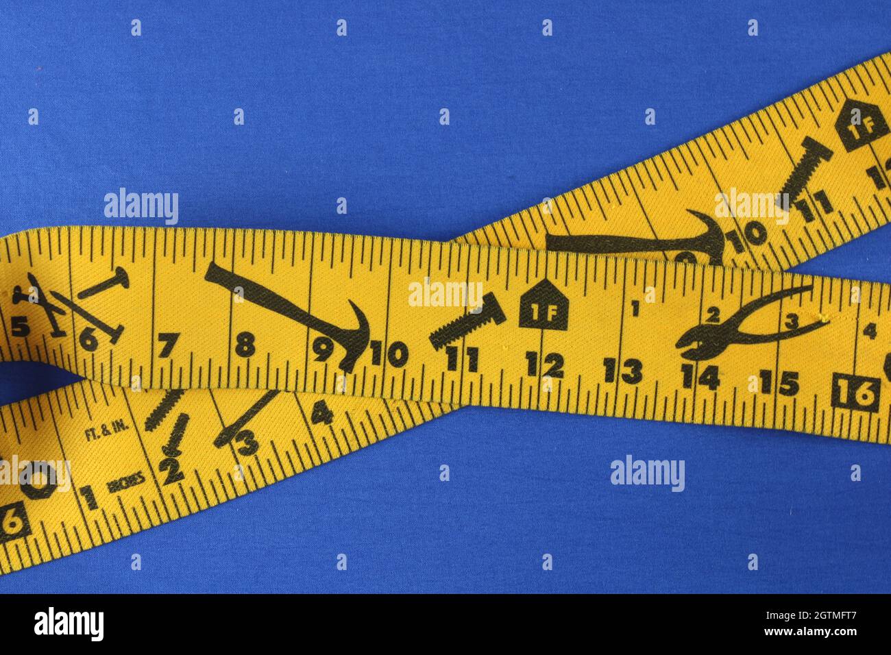 https://c8.alamy.com/comp/2GTMFT7/workmans-tape-measure-securing-straps-with-images-of-hammer-pliers-screws-and-nails-isolated-on-chroma-blue-background-with-copy-space-2GTMFT7.jpg