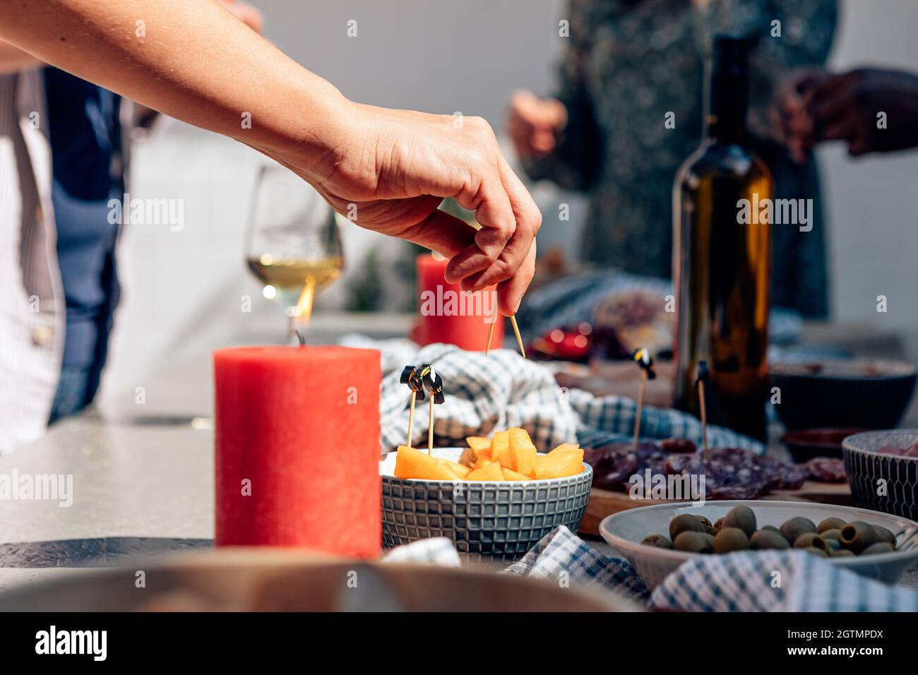Female Hand Holding Toothpick Piercing A Piece Of Melon On Party Table