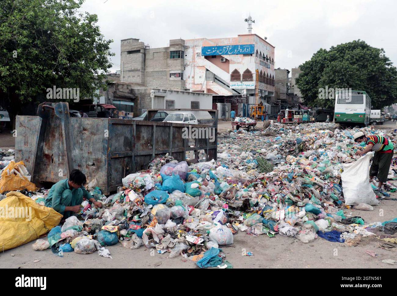 Garbage collectors are searching for useful things for sell by which they can earn their livelihood for support of their families, at a roadside garbage dump showing the negligence of concerned department, located on Jahangirabad area of Karachi on Saturday, October 02, 2021. Stock Photo