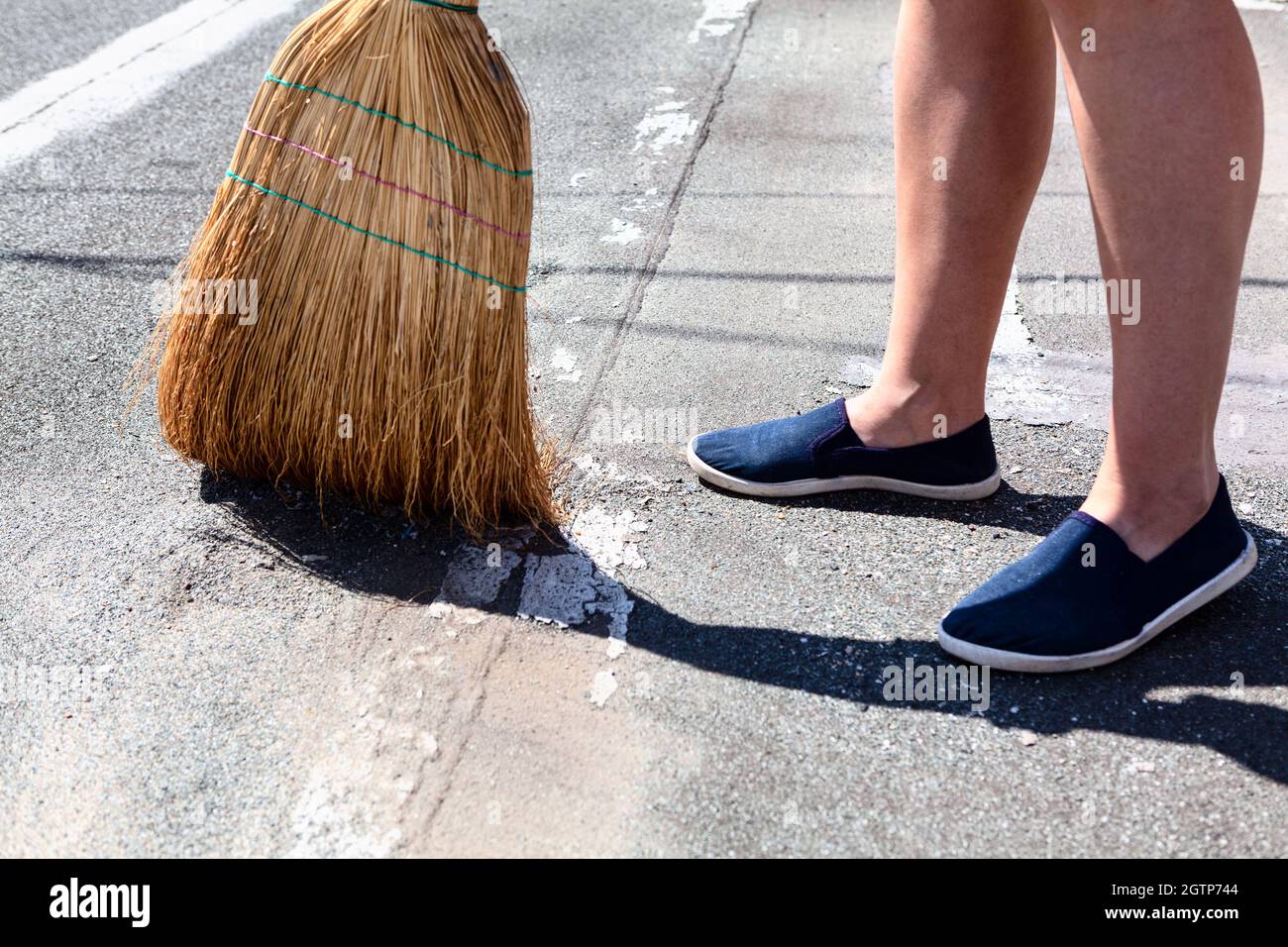 Exterior Cleaning with Corn Broom . Courtyard floor sweeping . Feet and