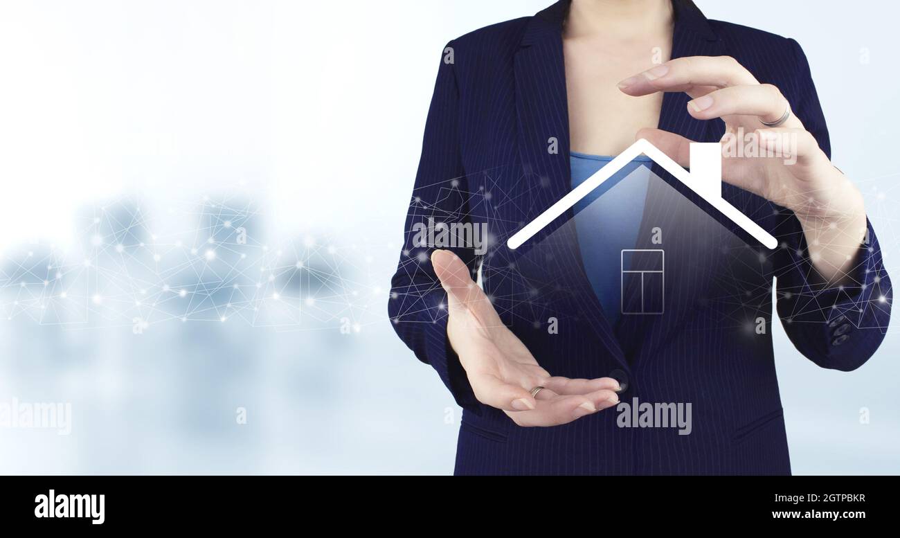 Repair and renovation, maintenance services. Two hand holding virtual holographic Smart Home icon with light blurred background. Smart home Automation Stock Photo