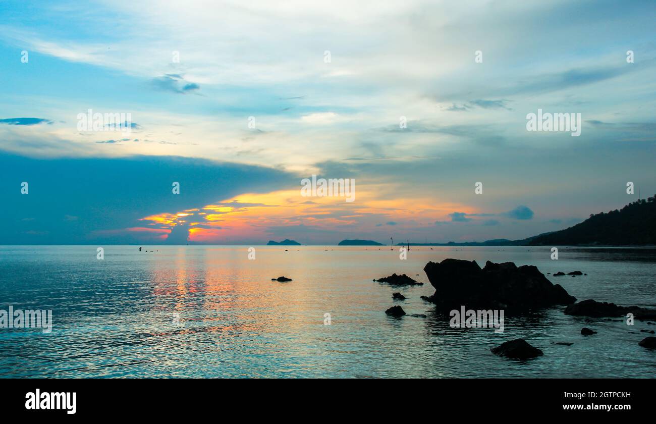 Peaceful sunset reflected on calm sea with silhouettes of rocks in the island of Koh Pha Ngan, Thailand. Relax, paradise destination concept Stock Photo