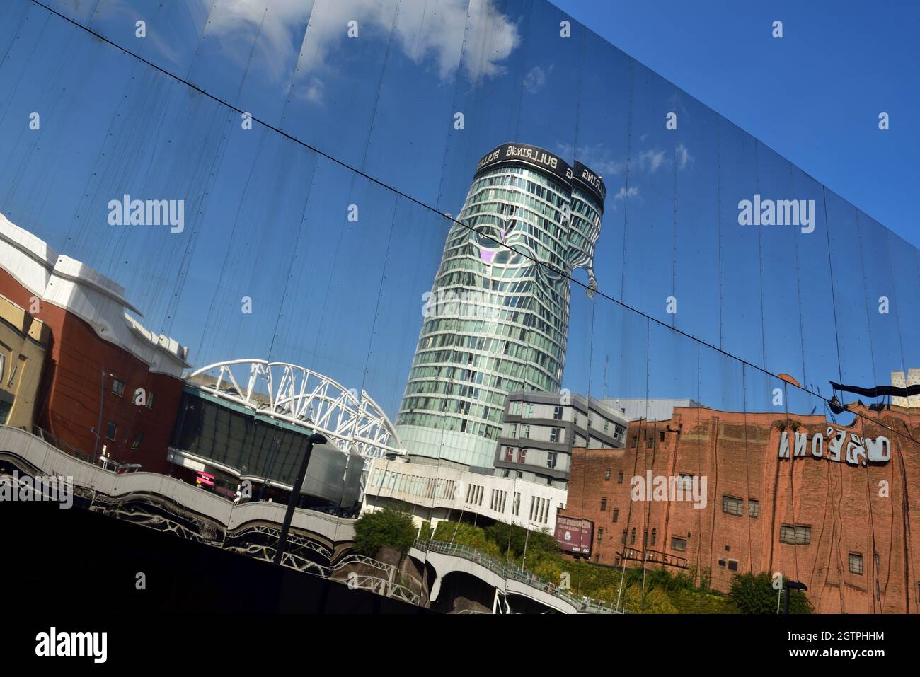 Reflections buildings off mirrored facade of Birmingham New Street station with distorted image of Rotunda and Bullring shopping Stock Photo