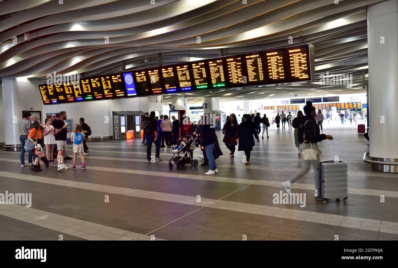 Inside Birmingham New Street station with people and departure board signs Stock Photo