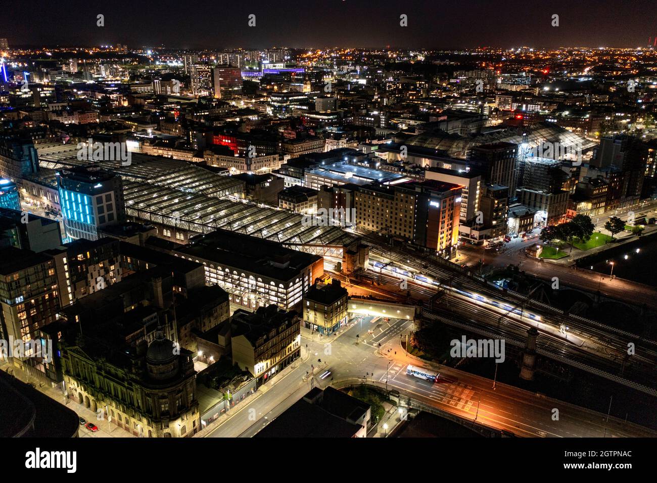 Glasgow, Scotland, UK. 29 September 2021 PICTURED:  Glasgow Central Station seen from the air at night. Glasgow Central connects trains to the West of Scotland and has a direct link with London down the West Coast line.  Aerial night drone view of Glasgow City Centre showing the lit up streets and the lights and coloured neon light shining and reflecting off of the glass exterior of the buildings.  Credit: Colin Fisher Stock Photo