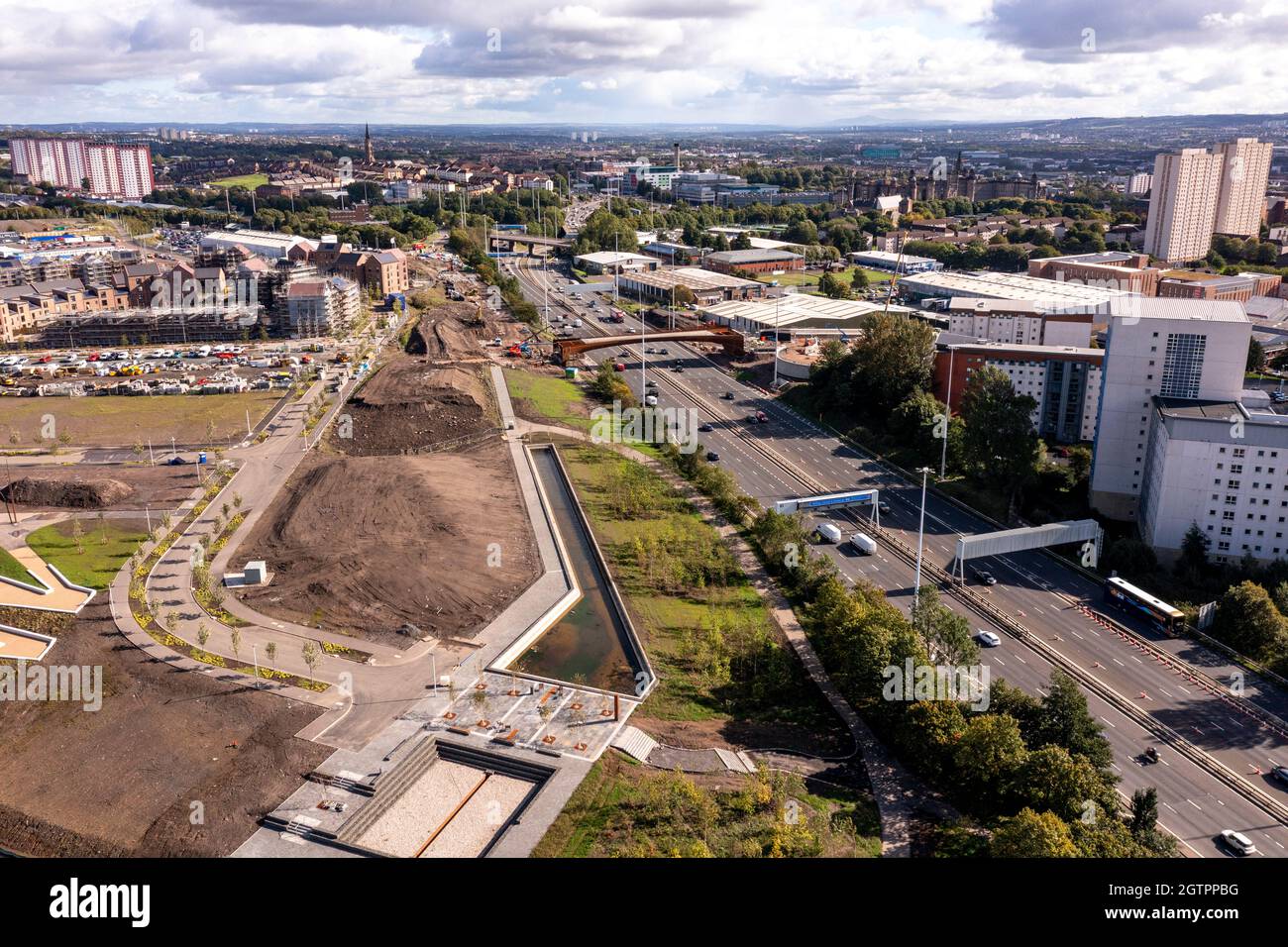 Glasgow, Scotland, UK. 29 September 2021 PICTURED:  New bridge at Sighhill over the M8 motorway. Aerial drone view of Glasgow’s Sighthill area showing the new bridge over the M8 Motorway which joins the north of the city centre form the East going through to Charing Cross. The Sighthill area is seeing a capital investment of £250million with new recreational areas and social housing to the north of the city. Also in the area are white water rafting and kayaking training centres along with wakeboarding training facilities. Credit: Colin Fisher Stock Photo