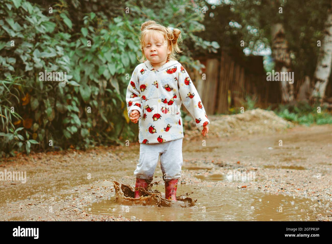 a child runs through puddles in rubber boots Stock Photo - Alamy