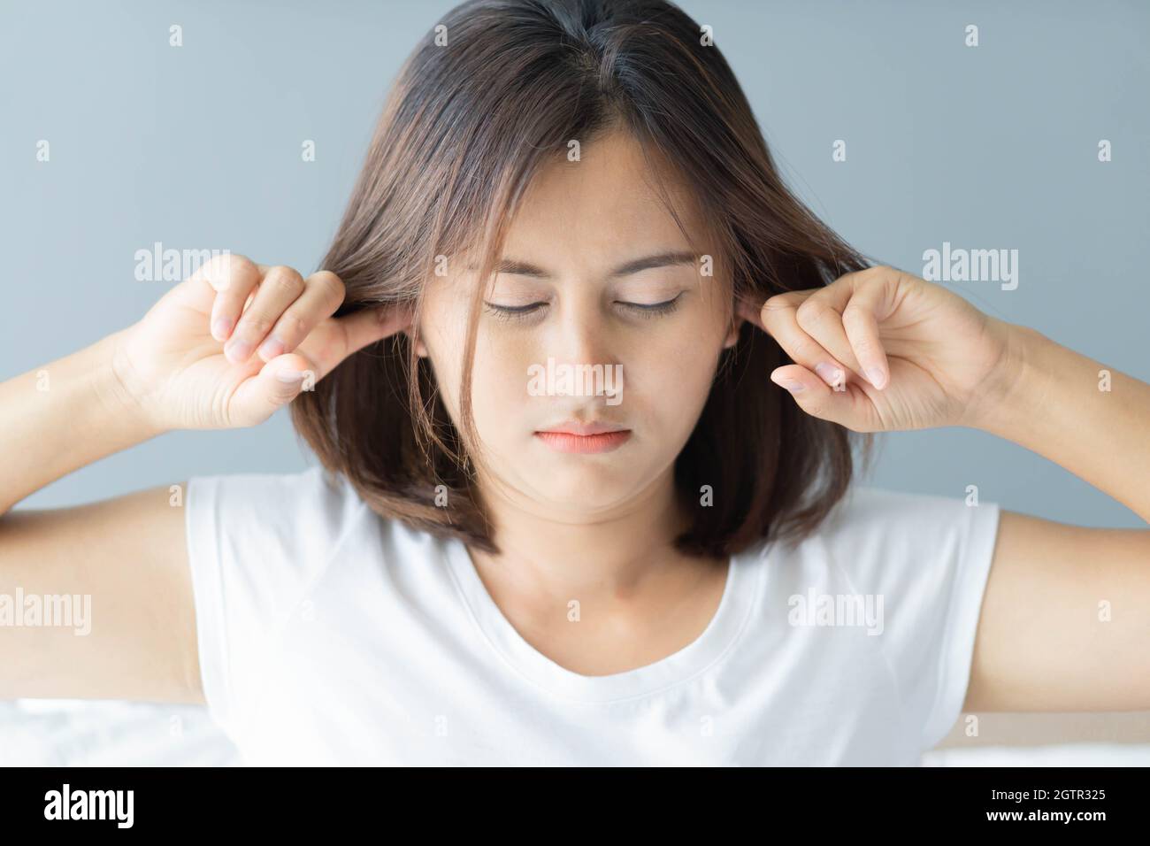 Close-up Of Angry Woman Covering Ears At Home Stock Photo