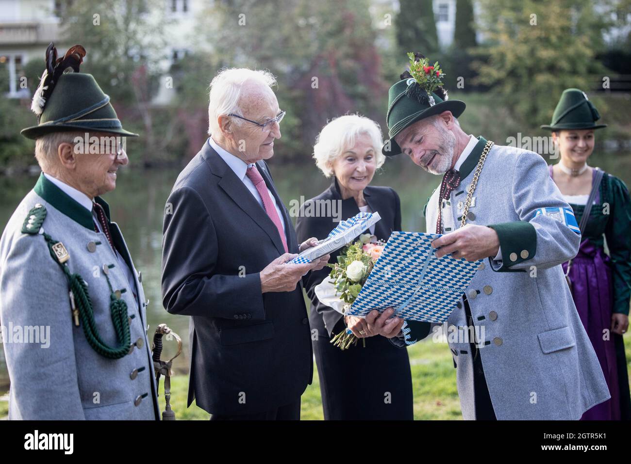 Wolfratshausen, Germany. 02nd Oct, 2021. Klaus Heilinglechner, mayor of Wolfratshausen (2nd from right, non-party), presents Edmund Stoiber, former CSU chairman (2nd from left), with a gift during a tribute at the ex-CSU party leader's 80th birthday party. Stoiber's wife Karin stands in the middle. On the left is Ewald Brückl, honorary captain of the Gebirgsschützen Wolfratshausen, on the right Lena Hochstraßer, sutler from the Gebirgsschützen Wolfratshausen. Credit: Matthias Balk/dpa/Alamy Live News Stock Photo