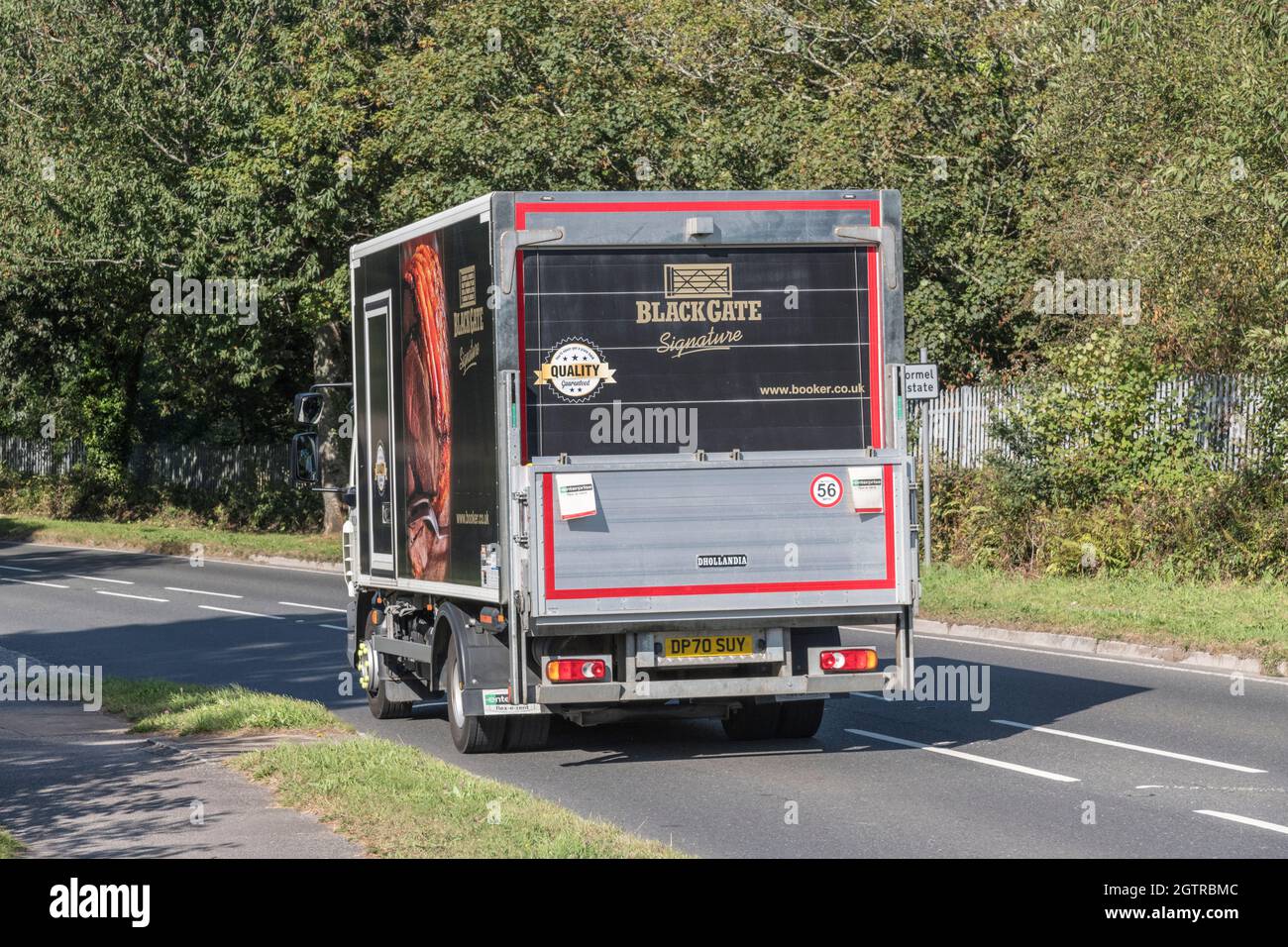 Booker catering supplies delivery truck travelllng downhill on country road. For UK driver shortage, food delivery during Covid, UK transport Stock Photo