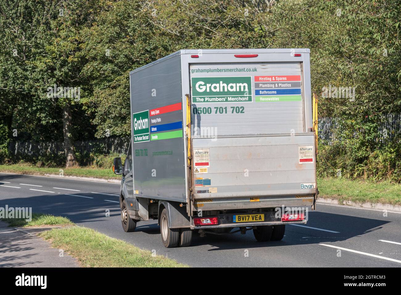 Graham plumbing supplies / merchant delivery truck going downhill on country road. For UK driver shortage, goods delivery during Covid, UK transport Stock Photo