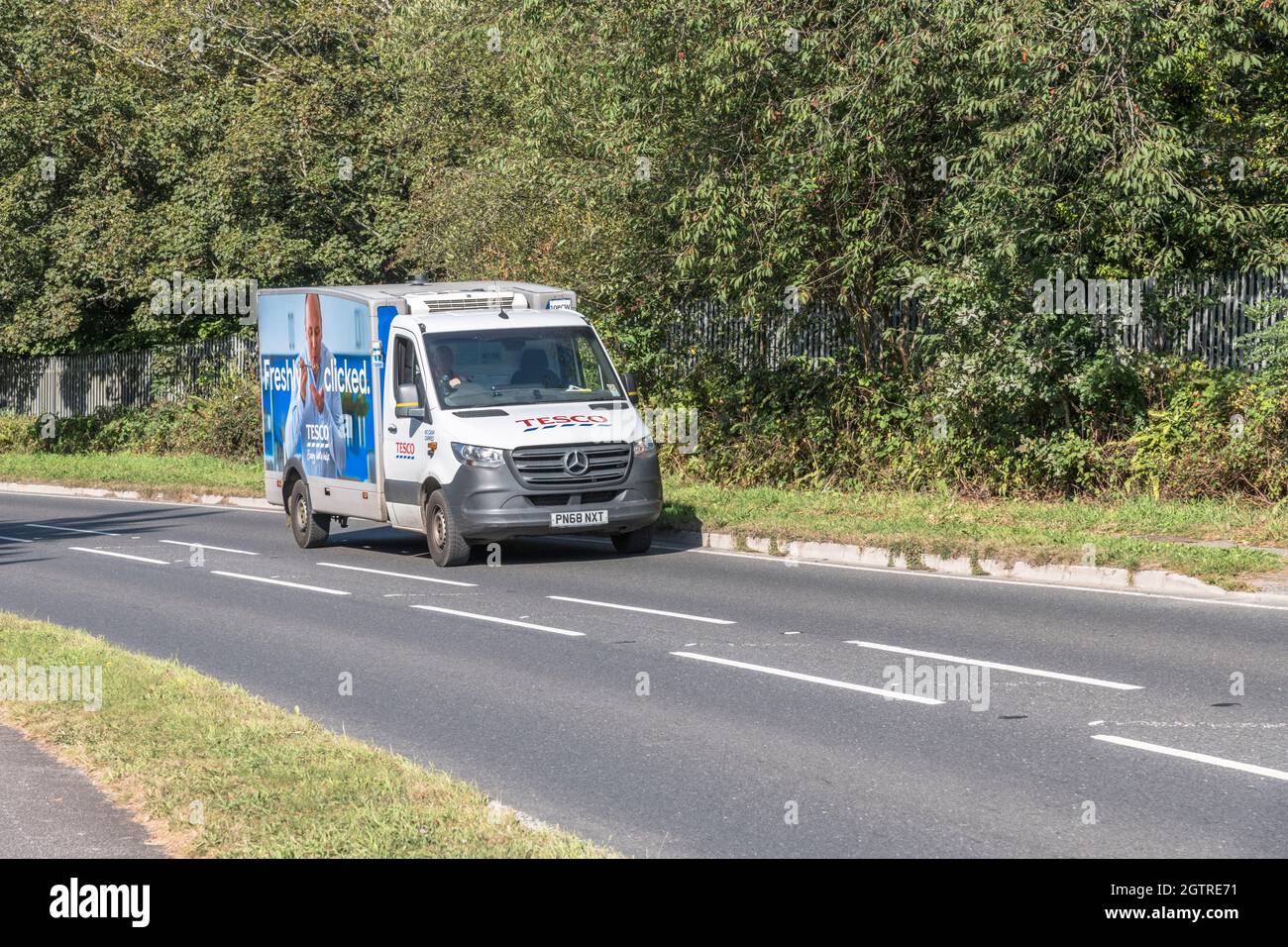 Tesco local delivery van travelling uphill on country road. For UK driver shortage, food delivery during Covid, UK transport, Mercedes vans. Stock Photo