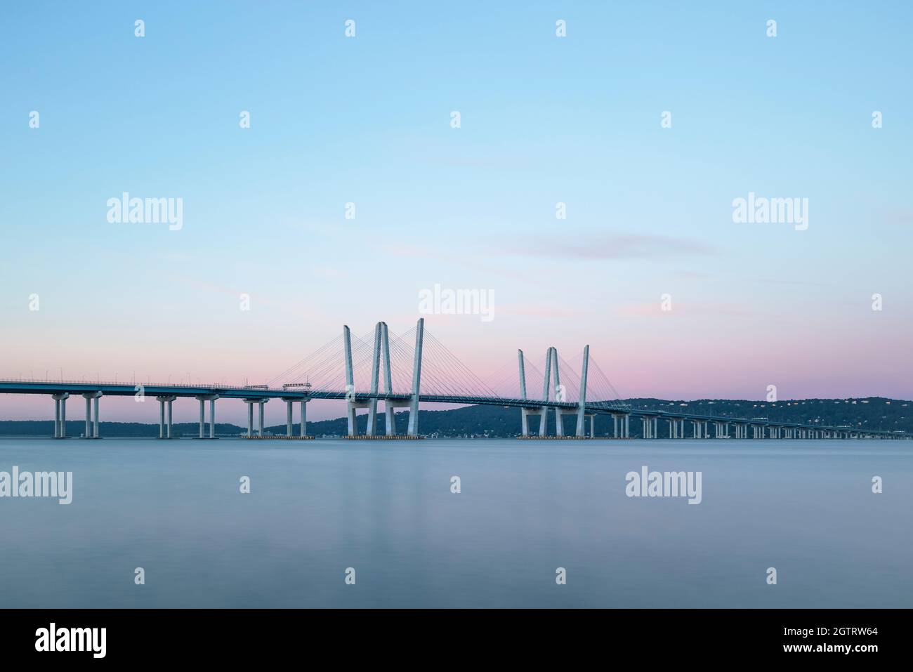 The Governor Mario M. Cuomo Bridge spanning the Hudson River at sunrise with sunlit pink/magenta clouds overhead. Stock Photo