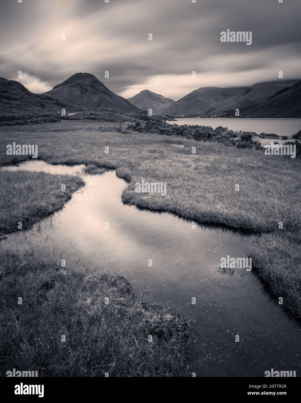 A long exposure captures the motion in the clouds scudding over the high fells at the head of Wasdale on a moody September evening. Stock Photo