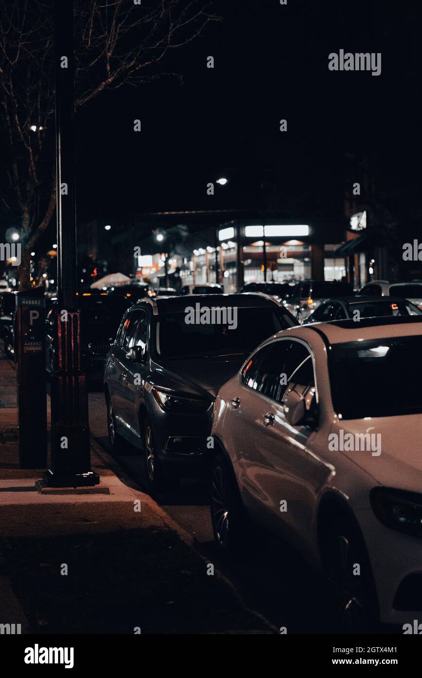 Vertical shot of parked cars outside at night Stock Photo - Alamy