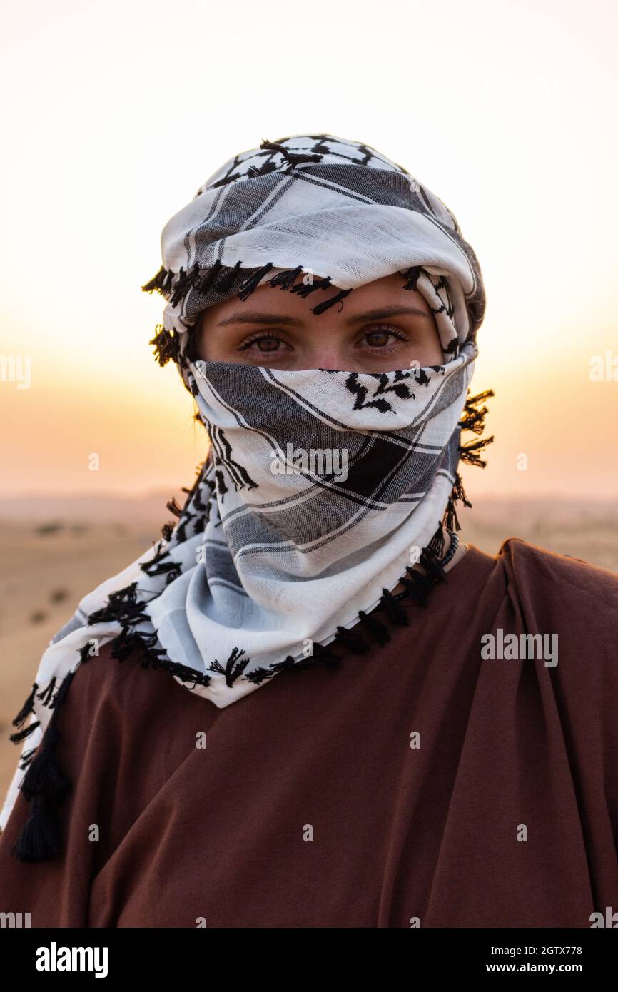 Portrait of a woman wearing a shemagh scarf against a desert landscape  Stock Photo - Alamy