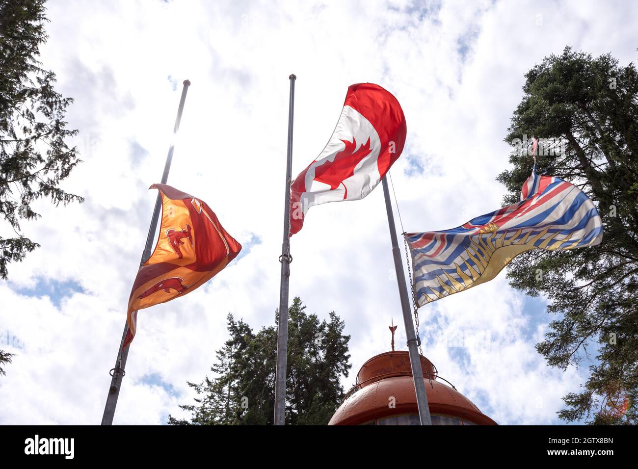 Canadian, British Columbia, and First Nations flag flying in Sooke on Canada Day. Stock Photo
